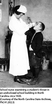School nurse examining student's throat, circa 1920
